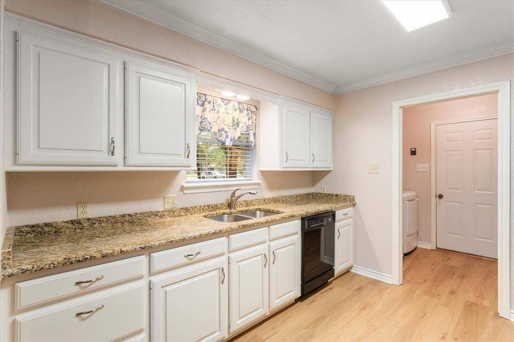 116 Meadowood Road, Enchanted Oaks, TX 75156 Kitchen featuring wood-finish flooring, white cabinetry, granite-style countertops, an undermount double basin sink, and a black dishwasher