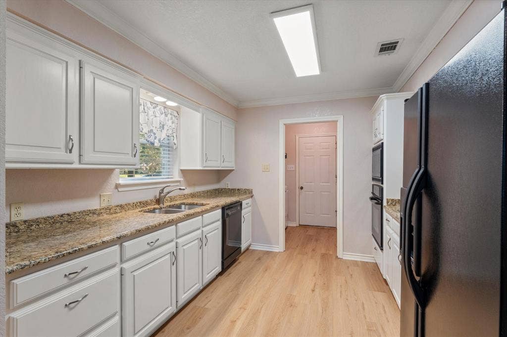 116 Meadowood Road, Enchanted Oaks, TX 75156 Kitchen featuring white cabinetry, granite countertops, stainless steel double basin sink, and wood-finish flooring