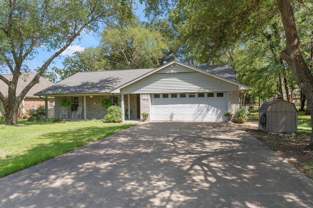 116 Meadowood Road, Enchanted Oaks, TX 75156 Single-story residence featuring a covered front porch, a two-car garage with panel windows, and a stone and siding exterior