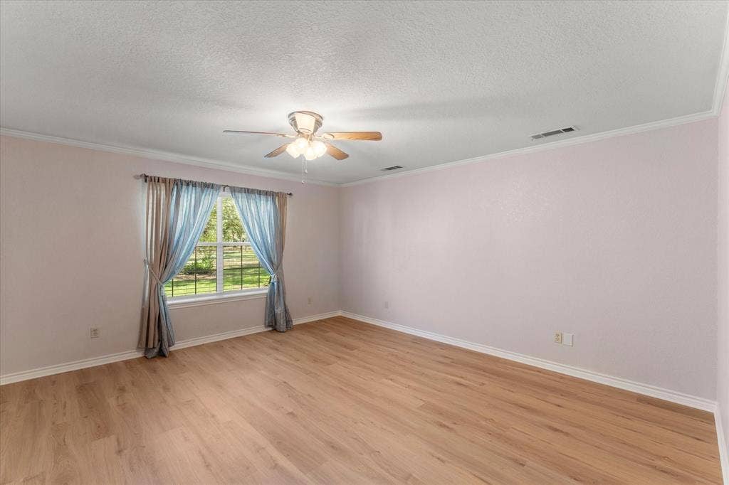 116 Meadowood Road, Enchanted Oaks, TX 75156 Spacious room featuring wood-finish flooring, a ceiling fan with integrated lighting, and a window providing natural light