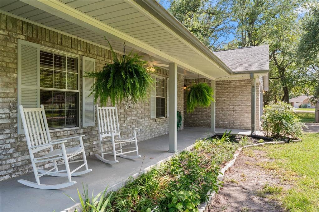 116 Meadowood Road, Enchanted Oaks, TX 75156 Brick exterior with a covered front porch, featuring a gray concrete surface, light-colored brick facade, and gray louvered shutters