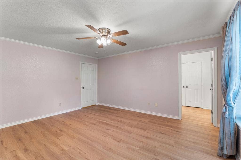 116 Meadowood Road, Enchanted Oaks, TX 75156 Spacious room with wood-finish flooring, ceiling fan with integrated lighting, and white trim molding