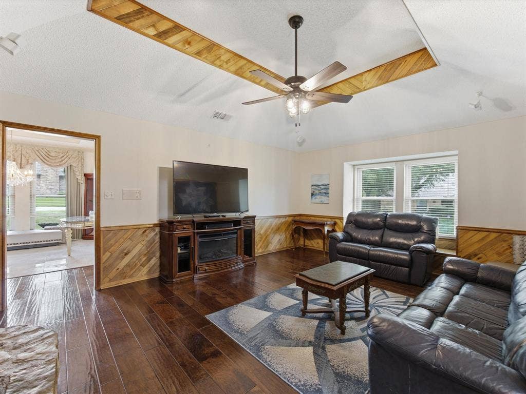 3701 Waycross Court, Arlington, TX 76016 Living area featuring wood-finish flooring, wood paneling, and a vaulted ceiling with decorative wood accents