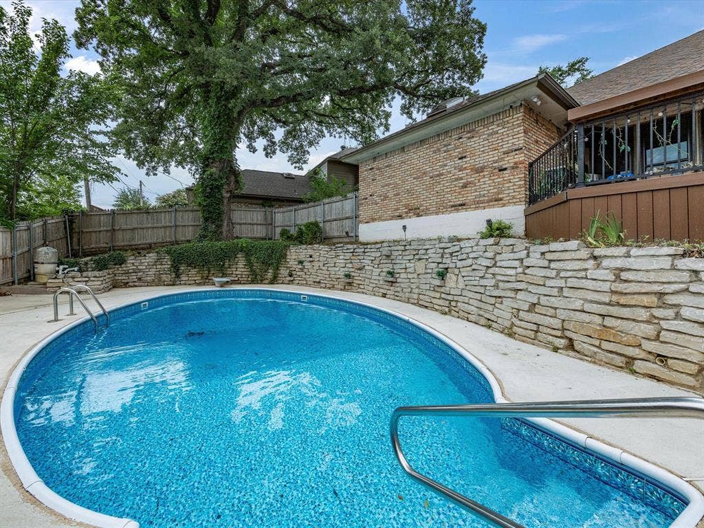 3701 Waycross Court, Arlington, TX 76016 Oval-shaped swimming pool featuring a bright blue liner and concrete decking