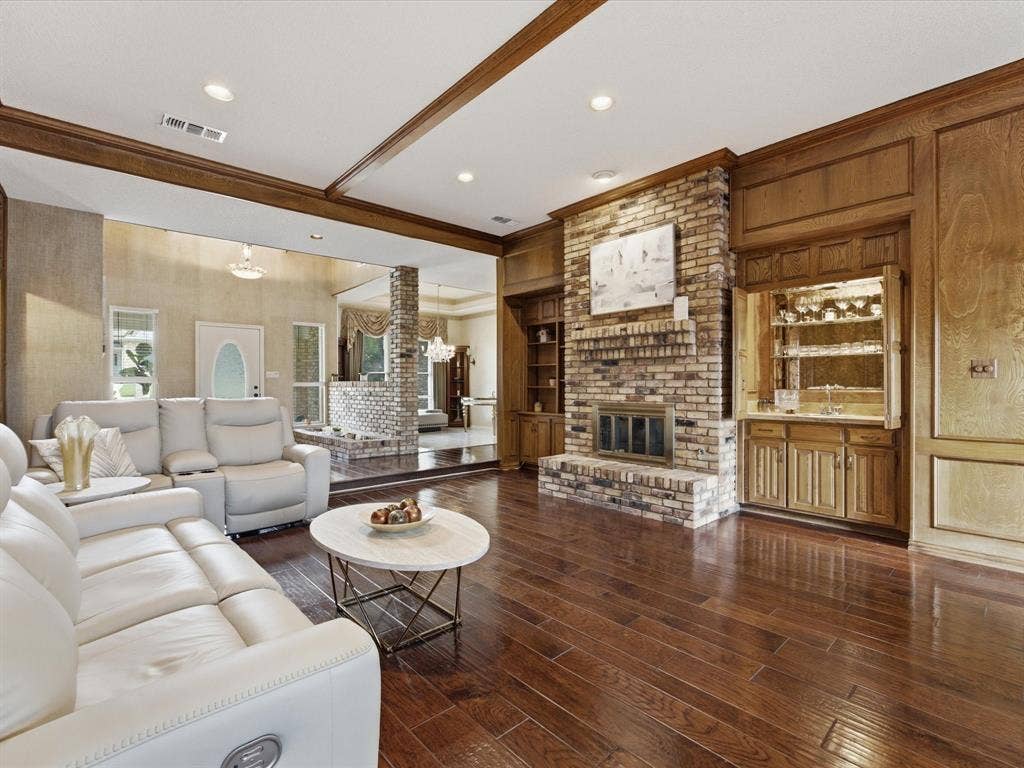3701 Waycross Court, Arlington, TX 76016 Open-concept living space featuring wood-finish flooring, a brick fireplace, and extensive wood paneling