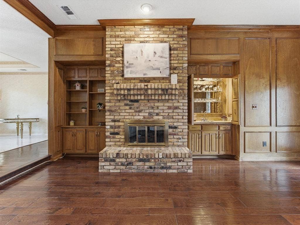 3701 Waycross Court, Arlington, TX 76016 Brick fireplace with wood mantle, flanked by built-in wood cabinetry and shelving