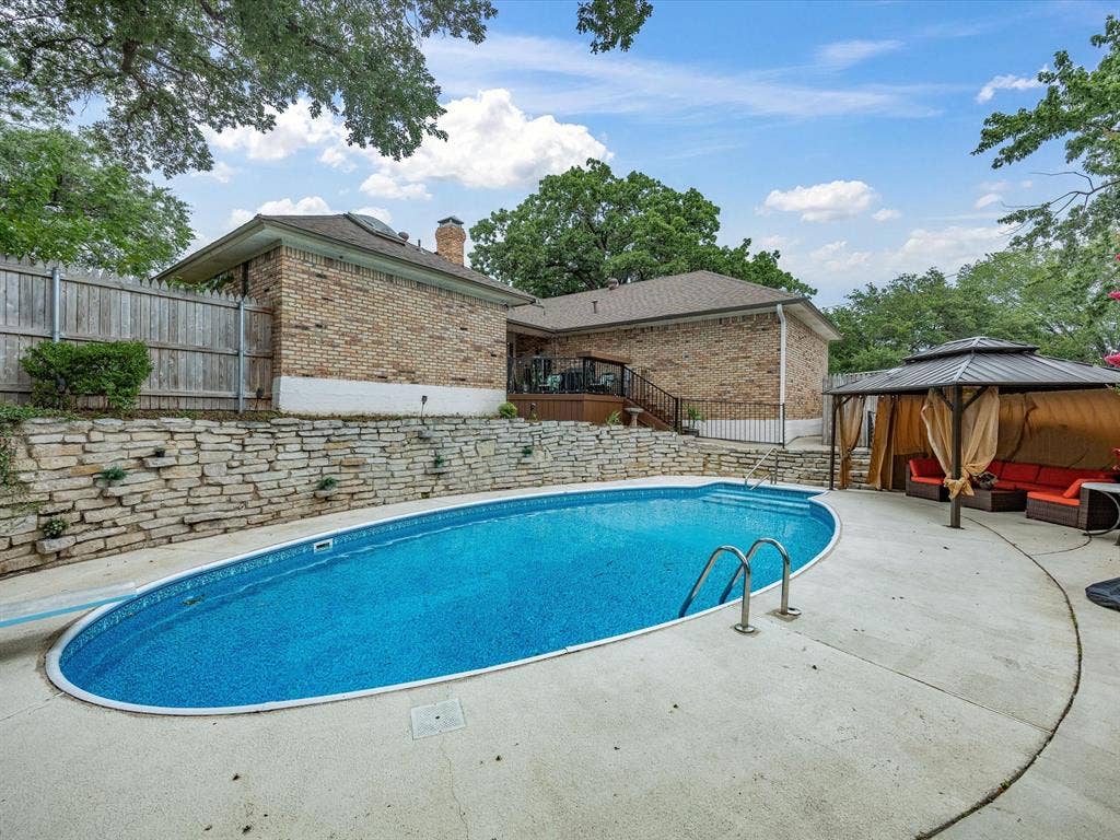 3701 Waycross Court, Arlington, TX 76016 Oval swimming pool with integrated steps, surrounded by a concrete patio