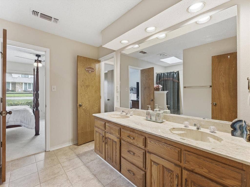 3701 Waycross Court, Arlington, TX 76016 Dual vanity with integrated sinks, light-toned countertop, and wood-finish cabinetry