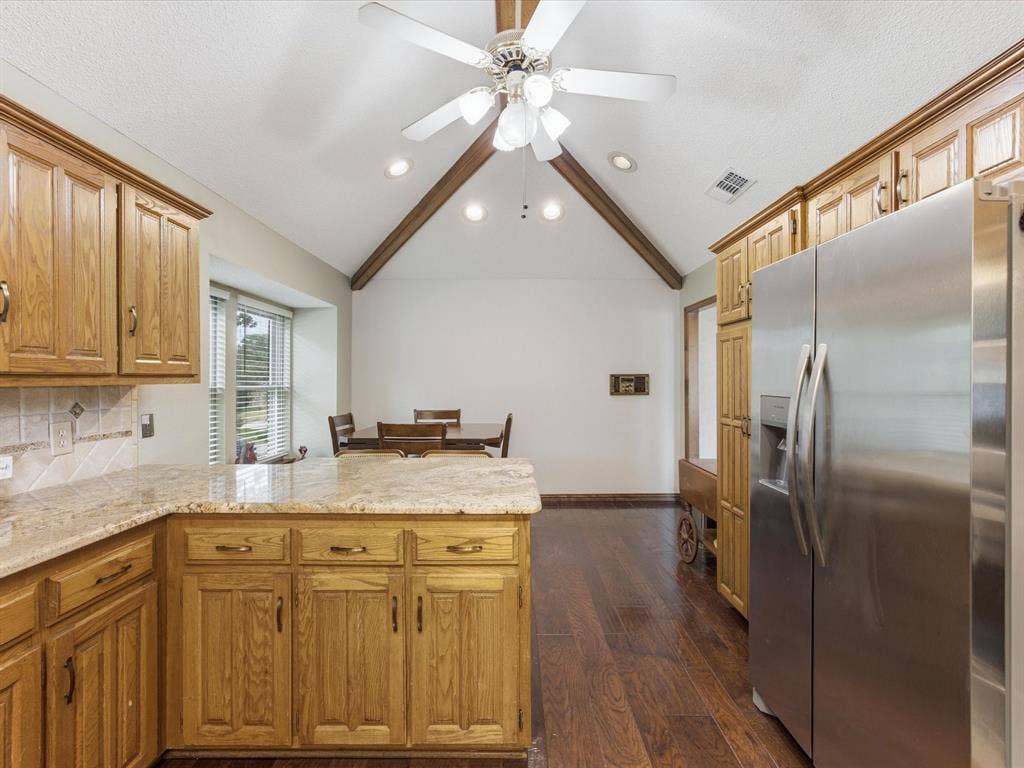 3701 Waycross Court, Arlington, TX 76016 Kitchen featuring wood-finish cabinetry, light granite countertops, and a tiled backsplash