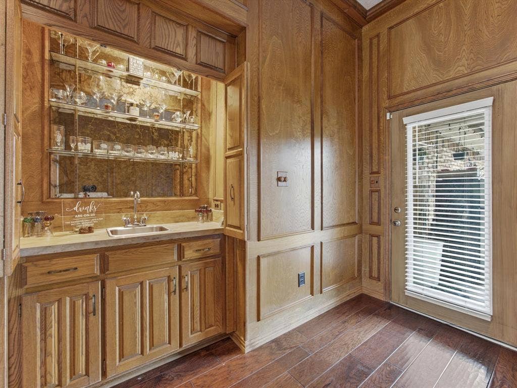 3701 Waycross Court, Arlington, TX 76016 Custom built-in wet bar featuring a stainless steel sink, mirrored backsplash, and glass shelving