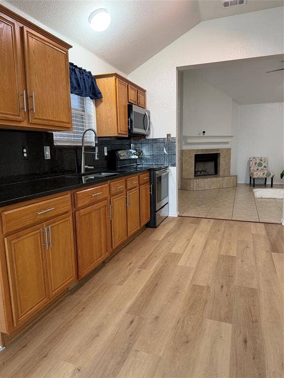 2648 Carmen Drive, Grand Prairie, TX 75052 Kitchen with wood-finish flooring, wood cabinetry, dark countertops, and stainless steel appliances