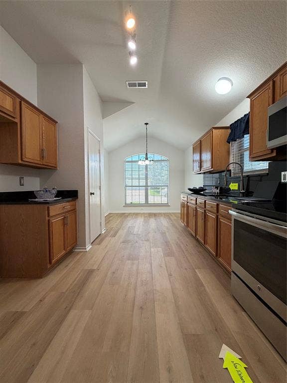 2648 Carmen Drive, Grand Prairie, TX 75052 Open-concept kitchen and dining area featuring wood-finish flooring, vaulted ceilings, and an arched window