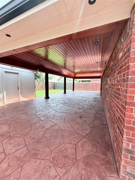2648 Carmen Drive, Grand Prairie, TX 75052 Expansive covered patio featuring stamped concrete flooring and a wood-finish ceiling with recessed lighting