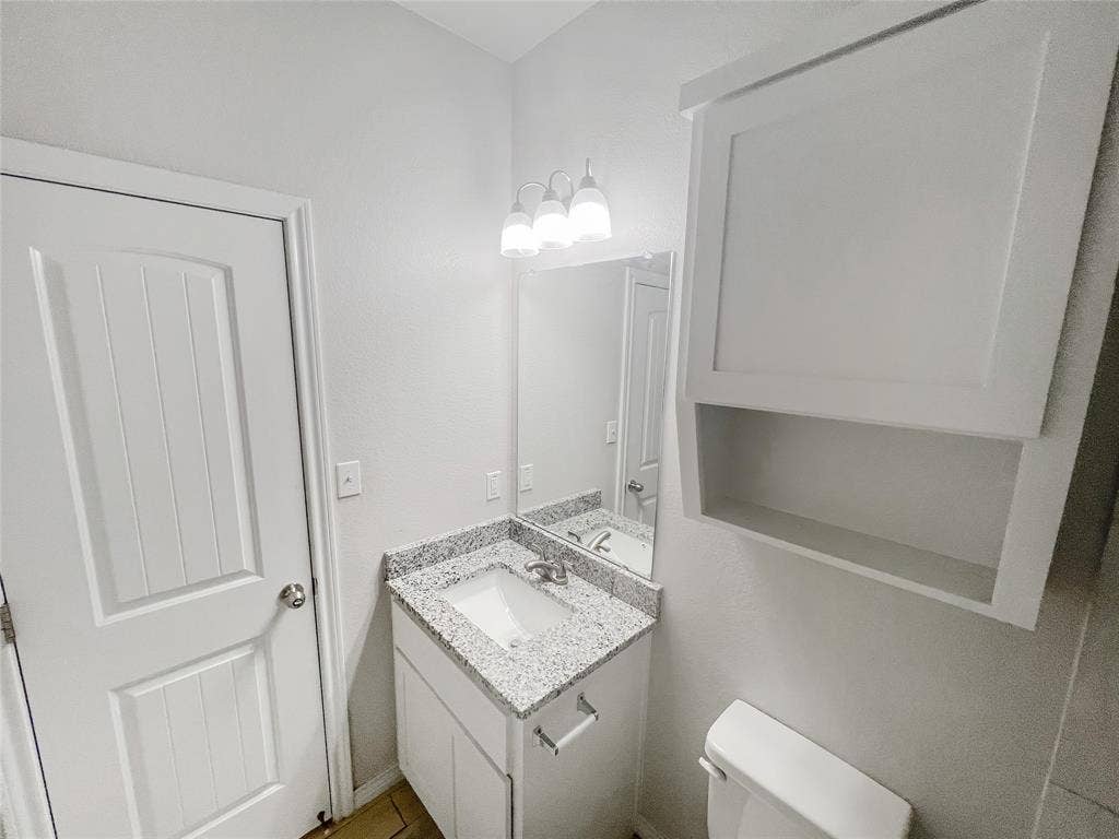 Bathroom vanity with a granite-look countertop and integrated sink