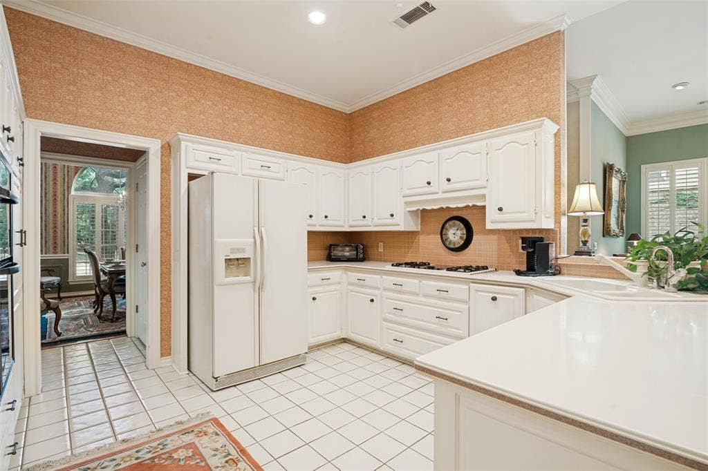 Kitchen featuring white cabinetry, tile flooring, and light-toned countertops
