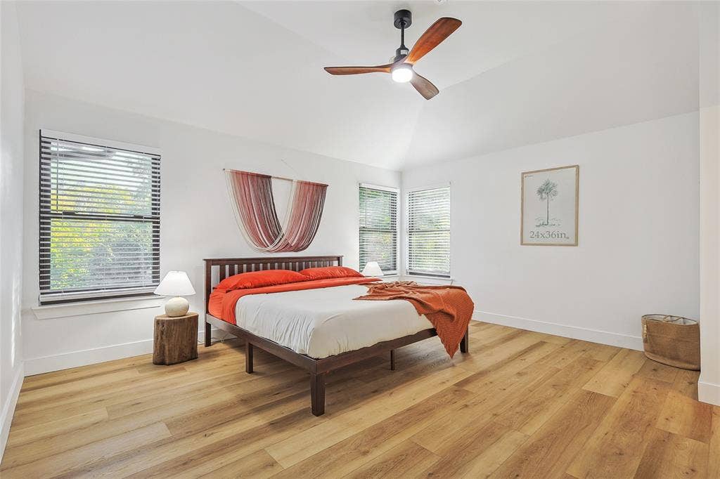 1088 Pondview Drive, Cedar Hill, TX 75104 Bedroom featuring baseboards, vaulted ceiling, light wood-style floors, and a ceiling fan