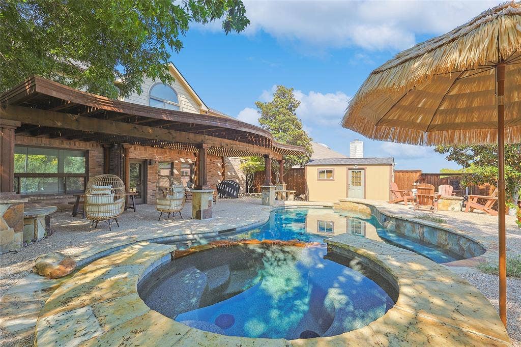 1088 Pondview Drive, Cedar Hill, TX 75104 View of pool with a patio, fence, an outdoor structure, and a pool with connected hot tub