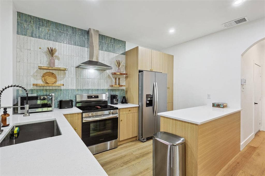 1088 Pondview Drive, Cedar Hill, TX 75104 Kitchen with open shelves, a sink, visible vents, wall chimney range hood, and appliances with stainless steel finishes
