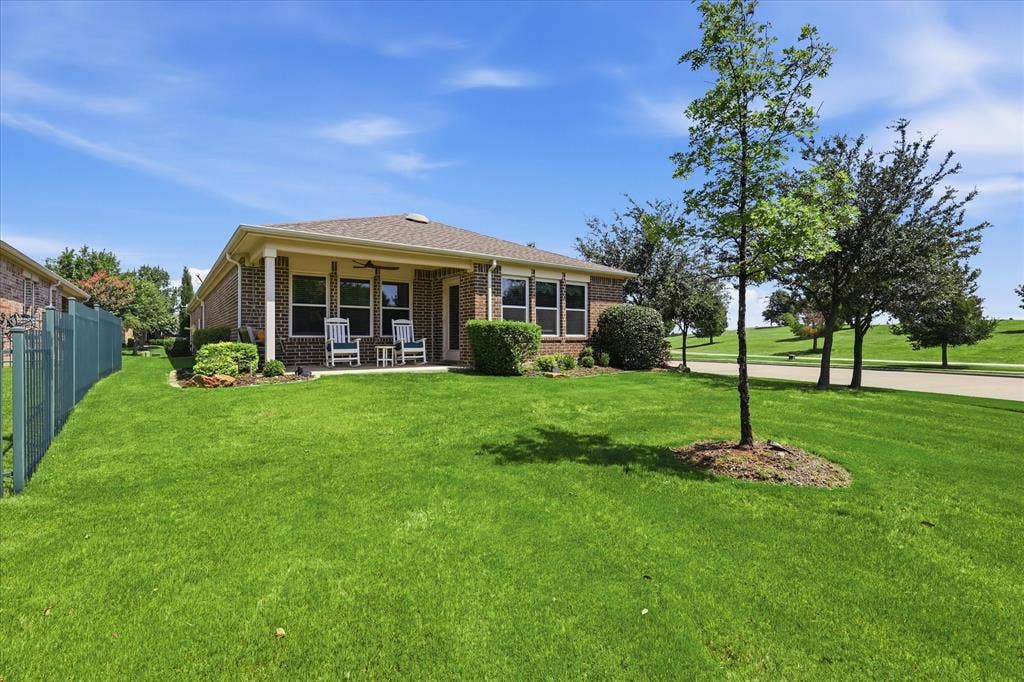 7594 Trull Brook Lane, Frisco, TX 75036 Brick exterior residence with a covered patio featuring a ceiling fan