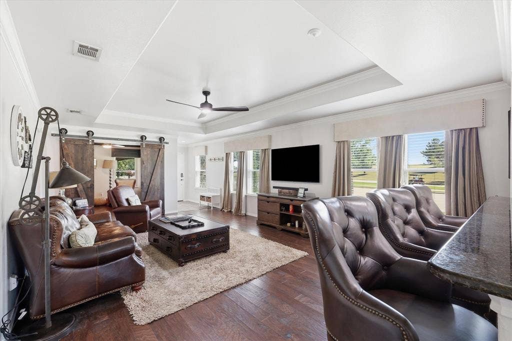 7594 Trull Brook Lane, Frisco, TX 75036 Spacious living area featuring wood-finish flooring, a tray ceiling, and a ceiling fan