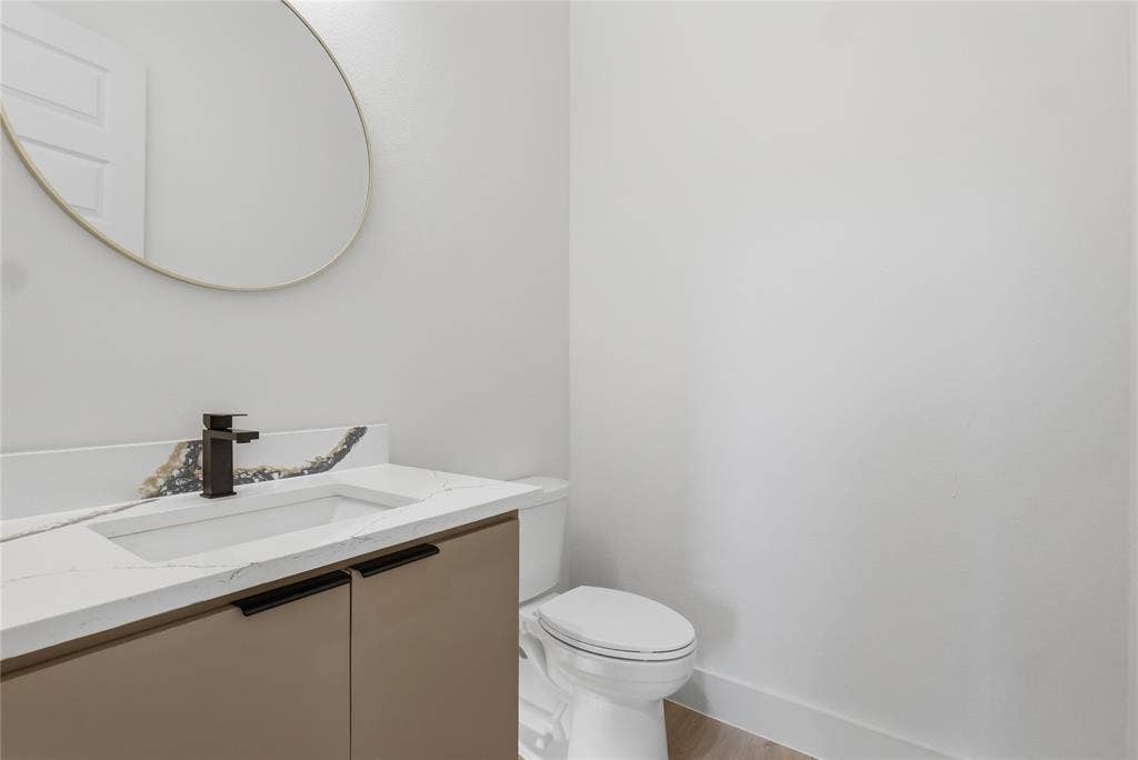 Contemporary vanity featuring an integrated rectangular sink, stone-finish countertop, and matte black faucet