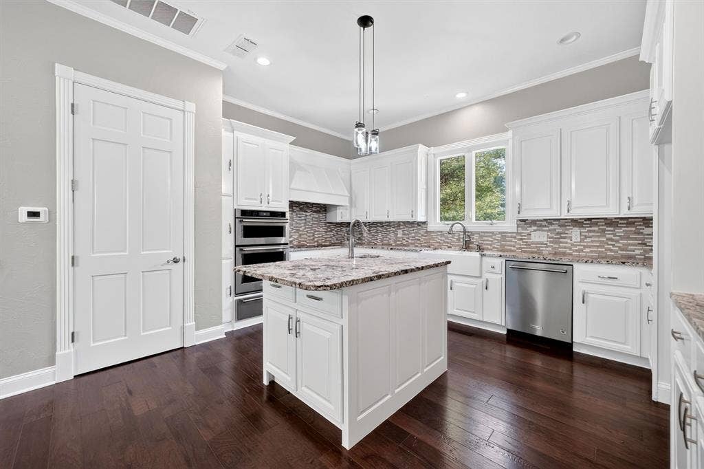 1201 Robbins Road, Athens, TX 75751 Kitchen featuring a central island with a stone-finish countertop, white cabinetry, dark wood-finish flooring, a farmhouse sink, and stainless steel appliances
