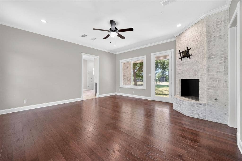 1201 Robbins Road, Athens, TX 75751 1st Floor- Primary Ensuite featuring a brick, wood burning fireplace. Exit Door for exclusive access to fenced backyard.
