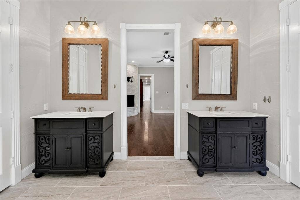 1201 Robbins Road, Athens, TX 75751 1st Floor-Dual black vanities with views of the primary bedroom & brick woodburning fireplace.