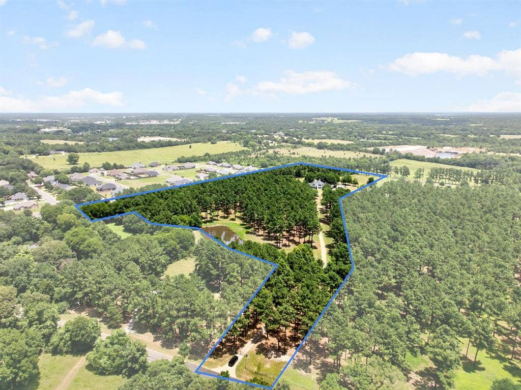 1201 Robbins Road, Athens, TX 75751 12.5 acres featuring souring pines, a stocked pond, private concrete driveway leading to a secluded residence- all located outside city limits with a 1D1 wildlife exemption.
