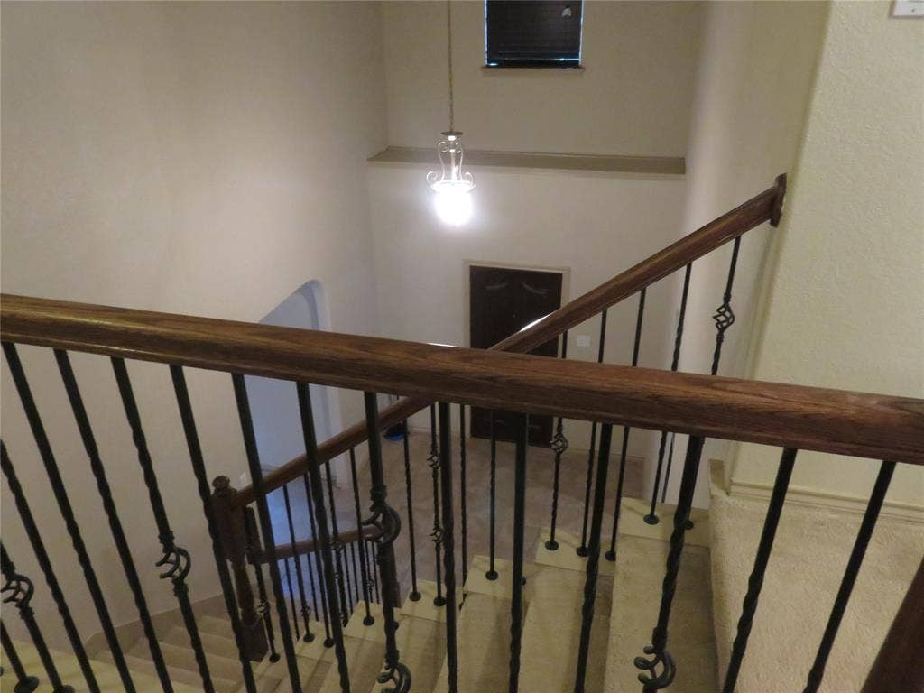 1122 Walter Stephenson Road, Midlothian, TX 76065 Staircase featuring wrought iron balusters with decorative elements, a polished wood handrail, and tiled steps
