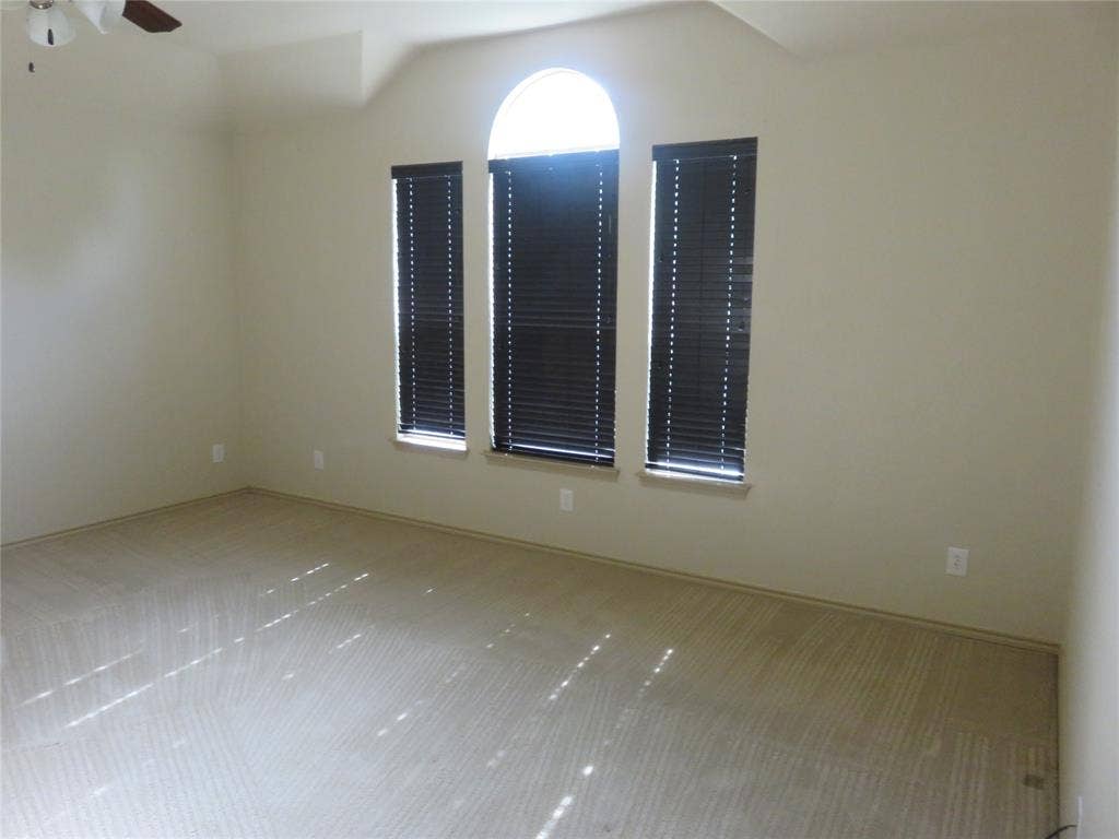 1122 Walter Stephenson Road, Midlothian, TX 76065 Carpeted room featuring a large arched window with two rectangular window panels below, each fitted with dark blinds