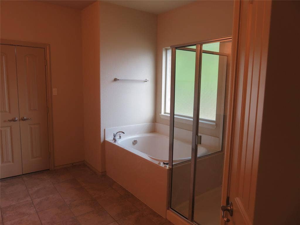 1122 Walter Stephenson Road, Midlothian, TX 76065 Bathroom featuring a soaking tub with mounted fixtures, a clear glass shower enclosure, and a window with privacy glass