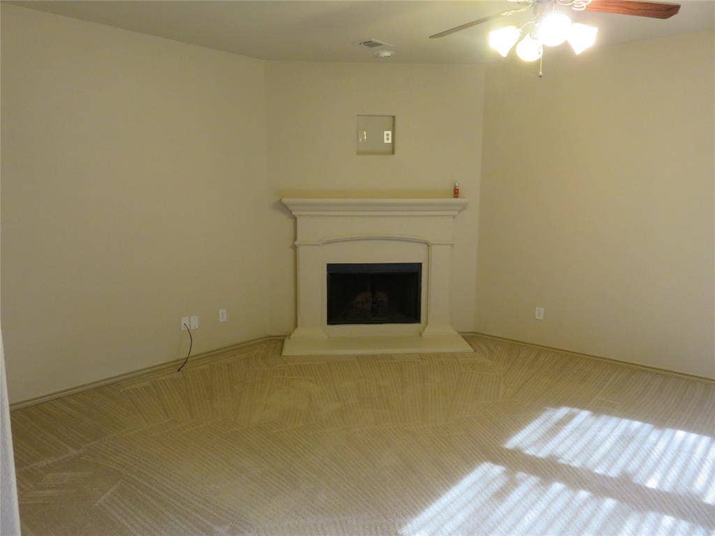 1122 Walter Stephenson Road, Midlothian, TX 76065 Built-in corner fireplace with a classic mantel, dark firebox, and hearth