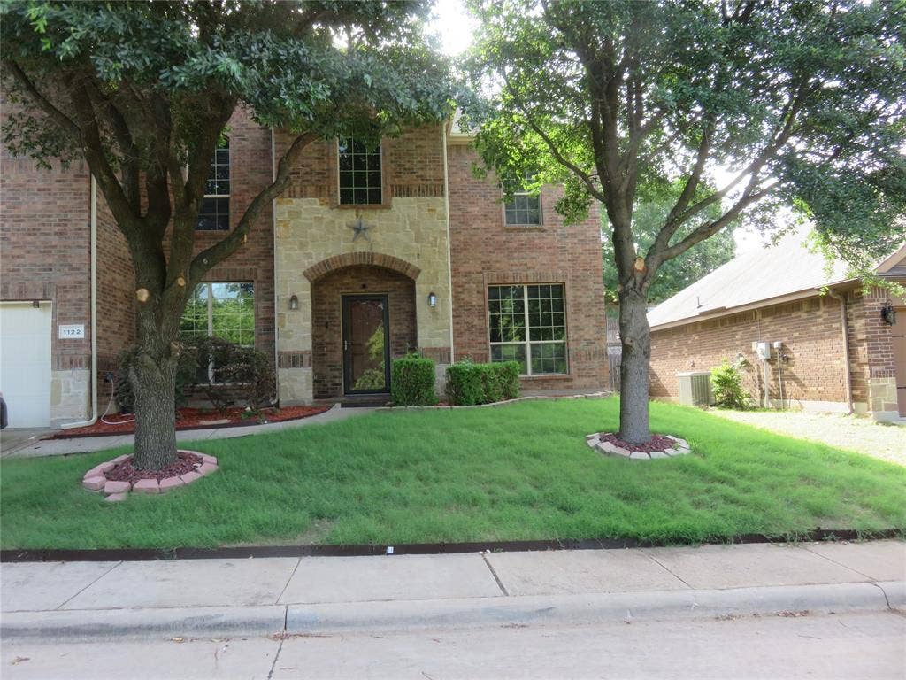 1122 Walter Stephenson Road, Midlothian, TX 76065 Brick and stone facade featuring an arched entryway with a glass-paneled door
