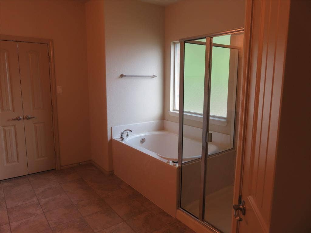 1122 Walter Stephenson Road, Midlothian, TX 76065 Bathroom featuring a built-in soaking tub, an enclosed shower with a glass door, and a privacy window