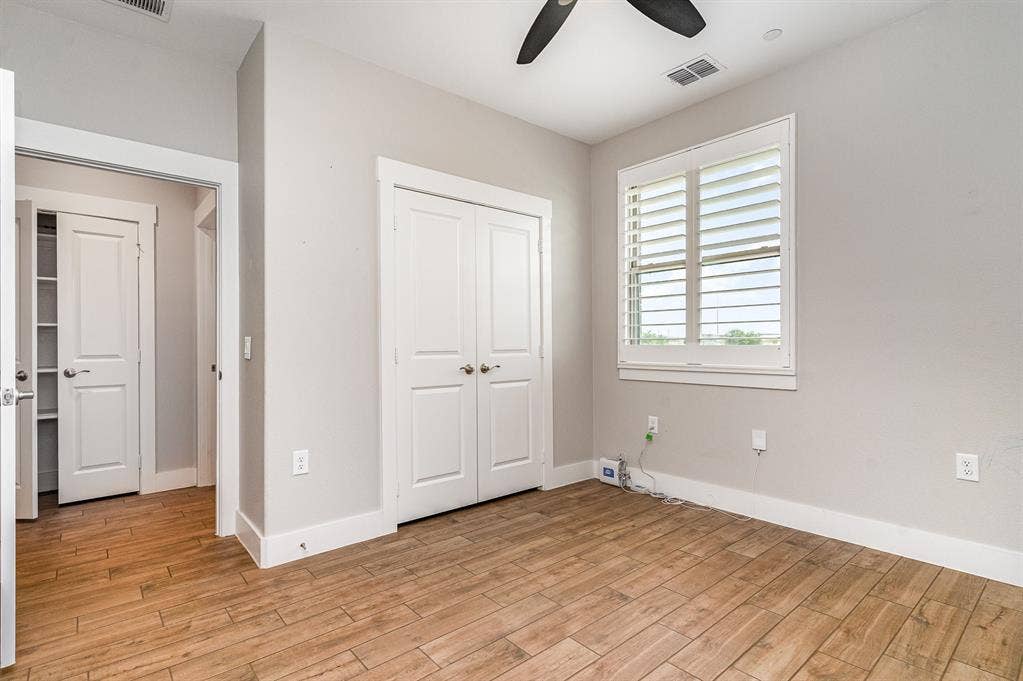 3861 Dalea Drive, Prosper, TX 75078 Secondary Bedroom featuring wood-finish flooring, a window with louvered shutters, a ceiling fan, and a double-door closet