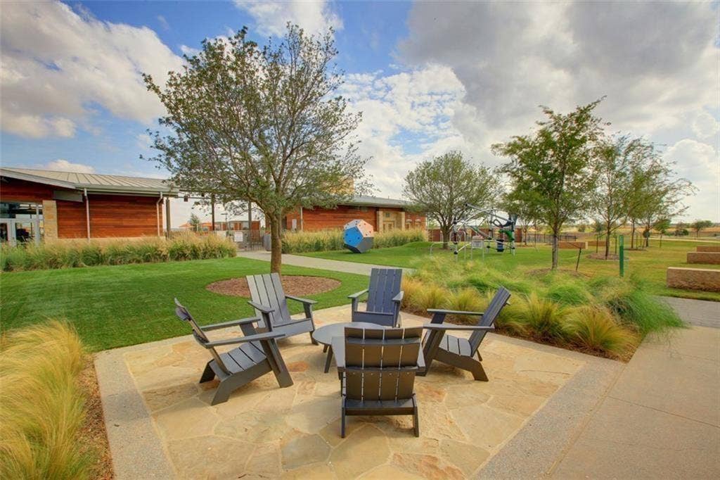3861 Dalea Drive, Prosper, TX 75078 Paved patio area with natural stone pavers and a concrete border, surrounded by manicured lawn and ornamental grasses