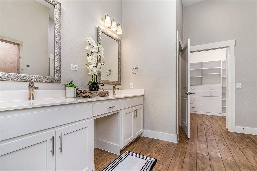 3861 Dalea Drive, Prosper, TX 75078 Primary Bathroom with dual vanities, white cabinetry, and brushed nickel fixtures