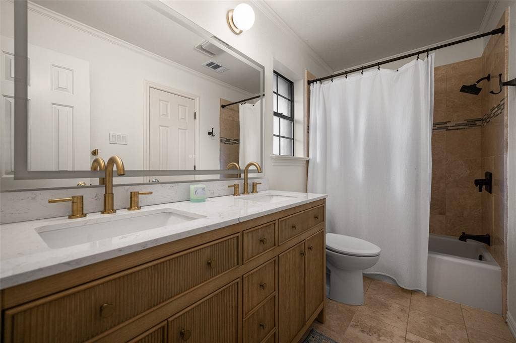 6501 Copper Creek Drive, Dallas, TX 75248 Bathroom featuring a double vanity with gold-tone fixtures, a white countertop, and integrated sinks