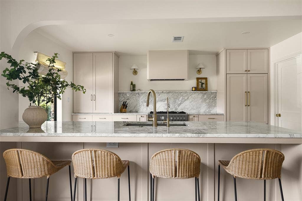6501 Copper Creek Drive, Dallas, TX 75248 Kitchen featuring a large central island with seating, a built-in range, a substantial range hood, and a full-height marble backsplash