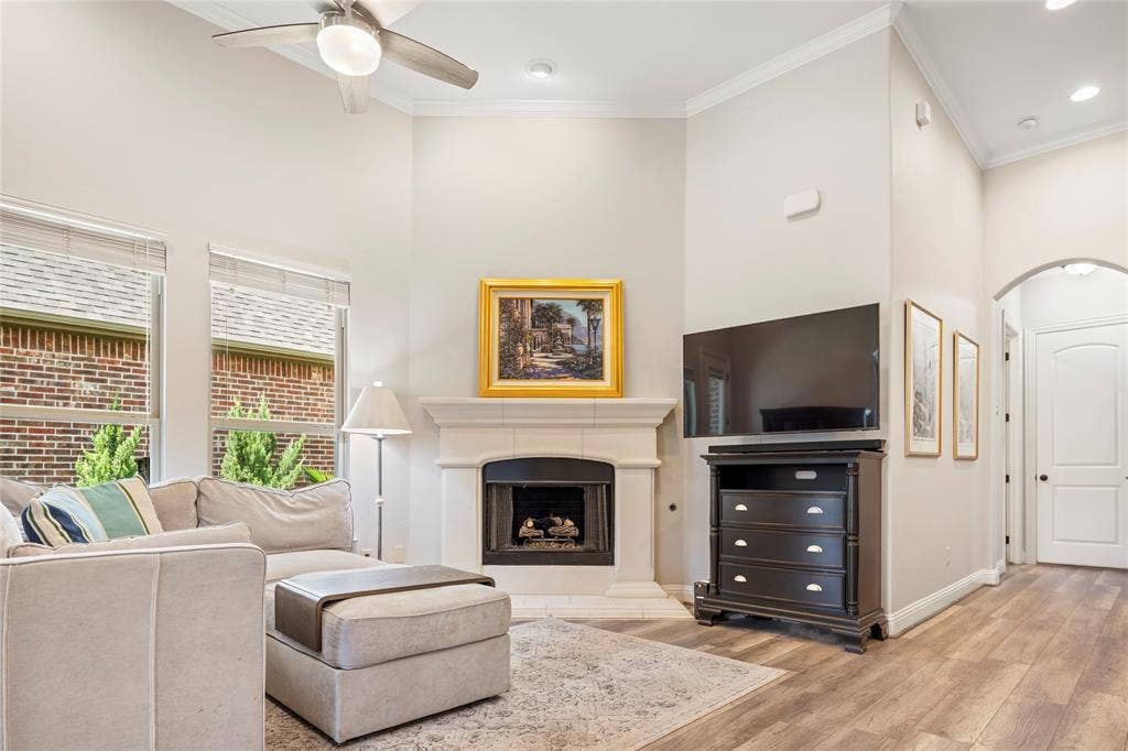 8721 Ludlow Drive, Frisco, TX 75036 Living room boasts a 12 foot ceiling, gas fireplace, picture windows, and luxury vinyl plank flooring.