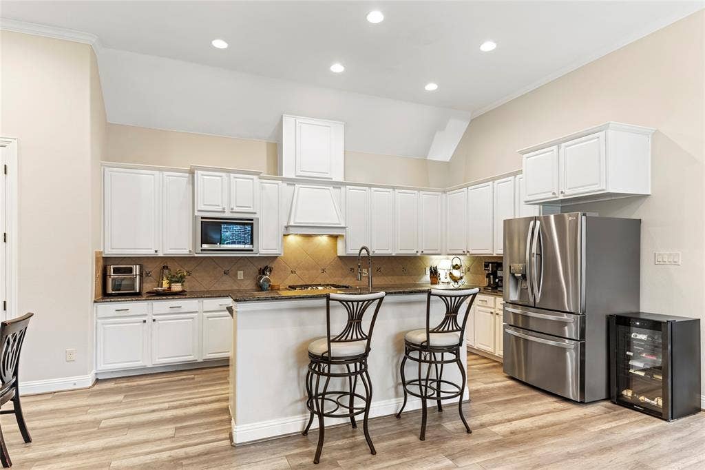 8721 Ludlow Drive, Frisco, TX 75036 Freshly painted cabinets, granite counters, gas cooktop, vented hood, LG oven & microwave, Kohler sink & faucet,