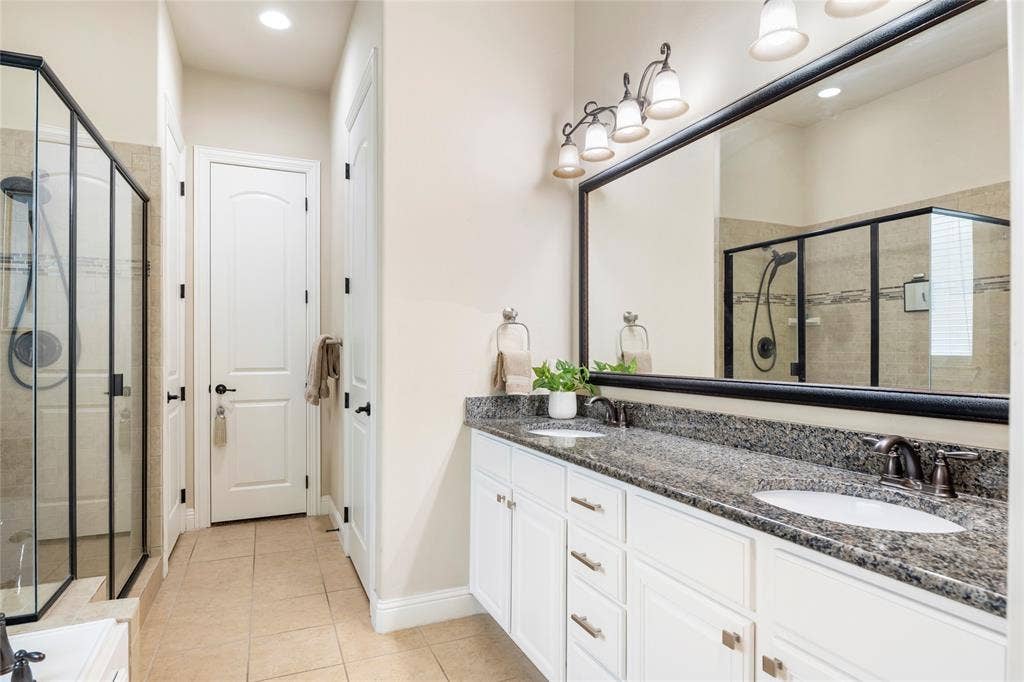 8721 Ludlow Drive, Frisco, TX 75036 Primary bathroom features granite counters, dual sinks, garden tub, separate shower, linen closet, and walk-in closet.