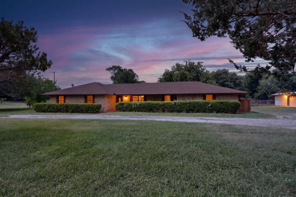 Ranch-style residence featuring a brick exterior and a brown shingle roof