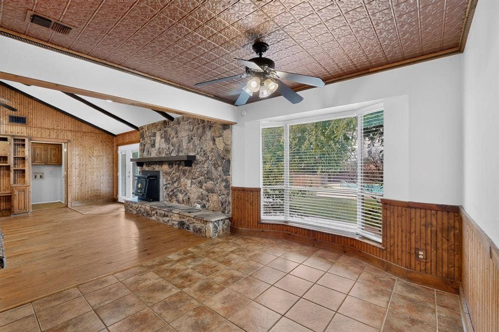 Dining area featuring a pressed metal ceiling, a bay window with horizontal blinds, and tile flooring