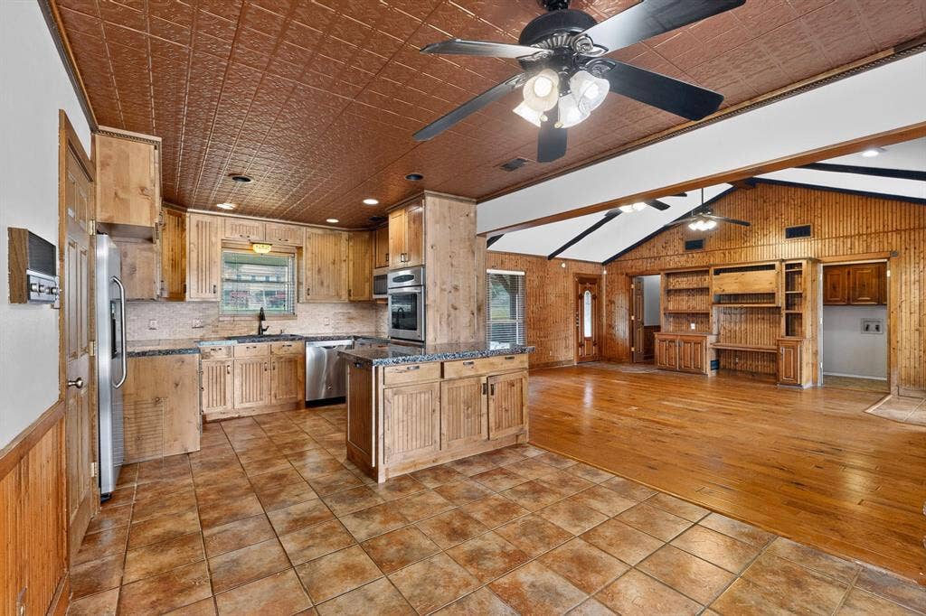 Kitchen featuring wood cabinetry, stainless steel appliances, and granite countertops