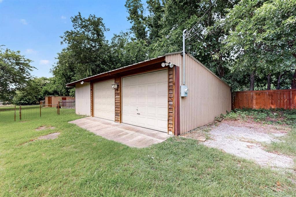 Detached two-car garage with corrugated metal siding and two overhead doors