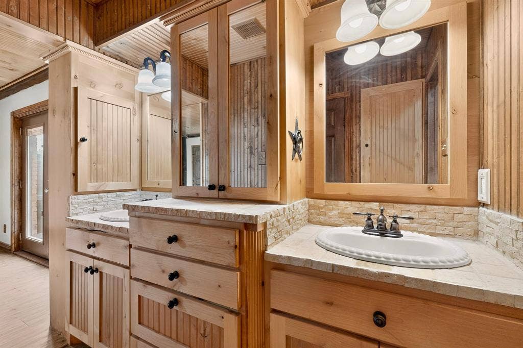 Dual vanity with light wood cabinetry and built-in medicine cabinets