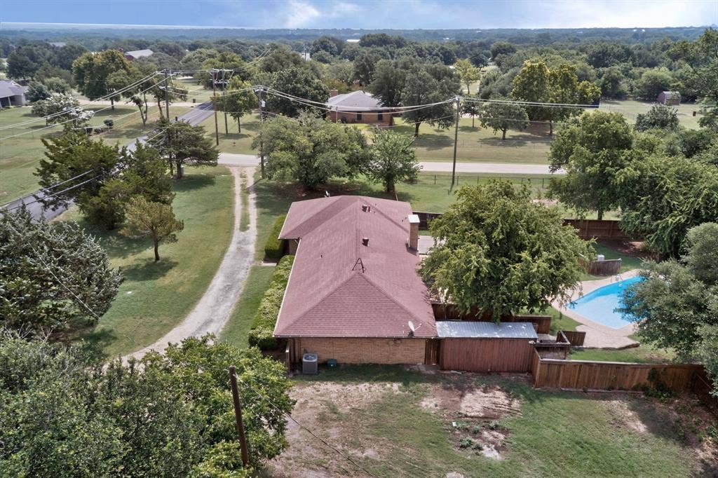 Aerial view showcasing a single-story brick residence with a gabled roof