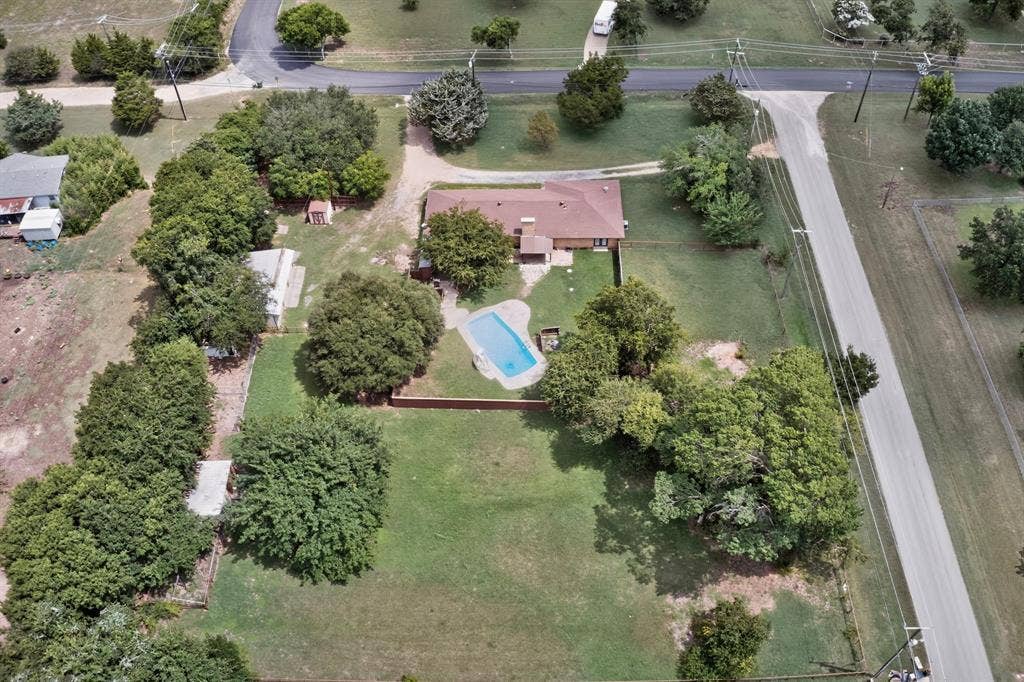 Aerial depiction of a property featuring a single-story residence with a red-brown roof